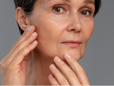 Mature woman examining the skin on her face